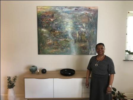 Eme O. Willie in front of one of her paintings